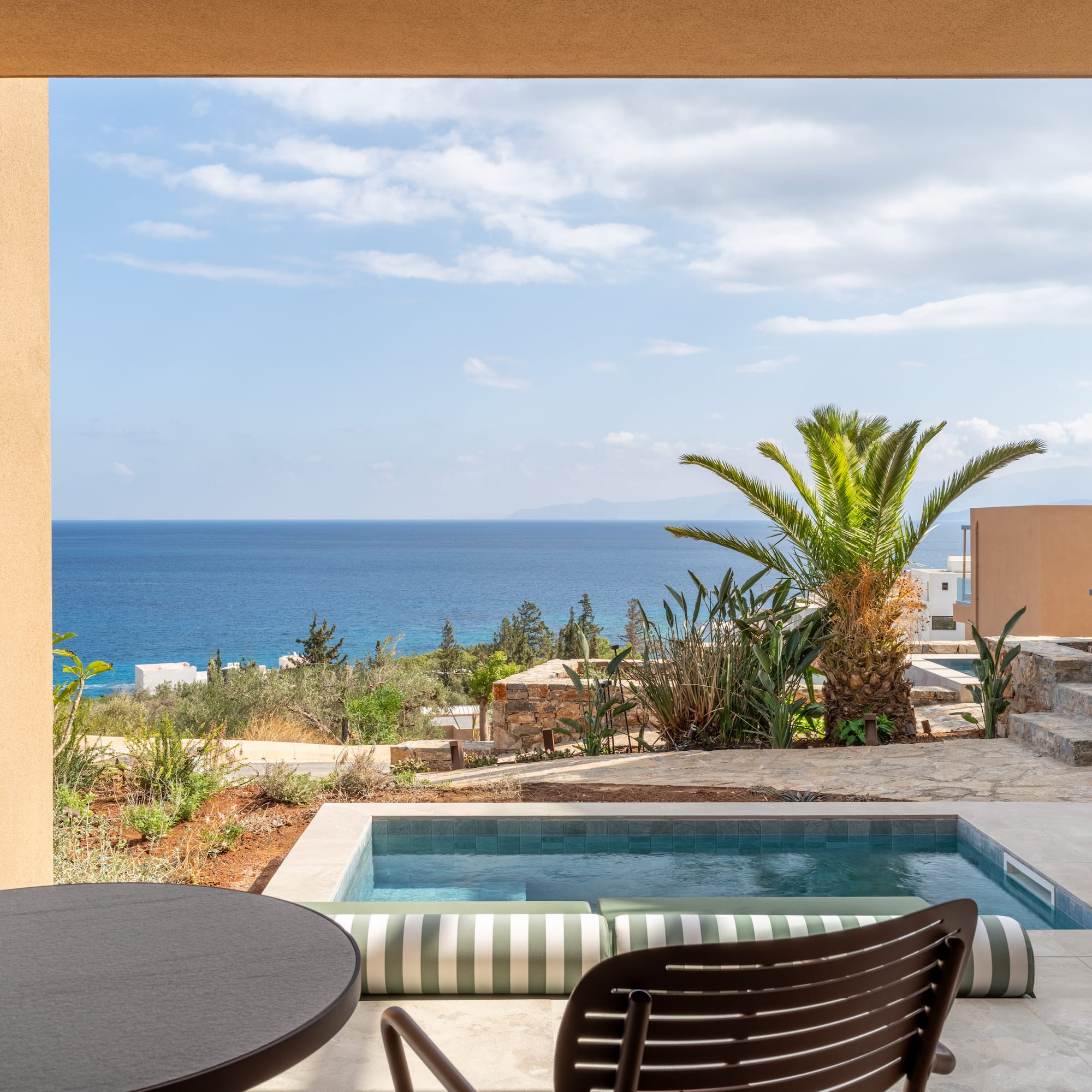 a pool with a table and chairs overlooking the ocean