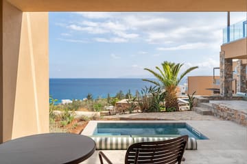a pool with a table and chairs overlooking the ocean