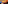 Breakfast buffet with colorful cast iron pots: fried eggs, bacon, raw eggs.