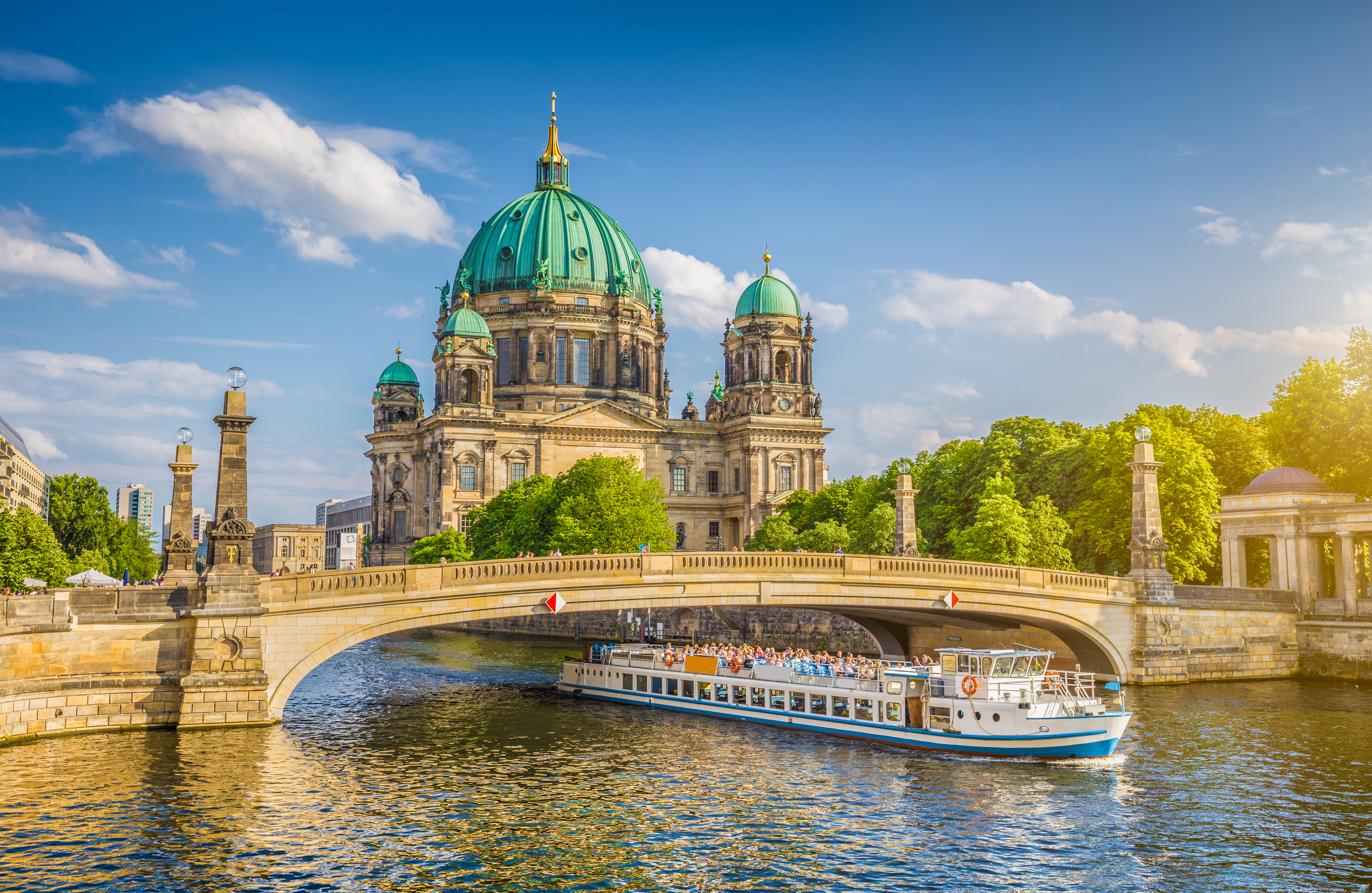 Berliner Dom with a tour boat on the Spree River and a bridge, Berlin.
