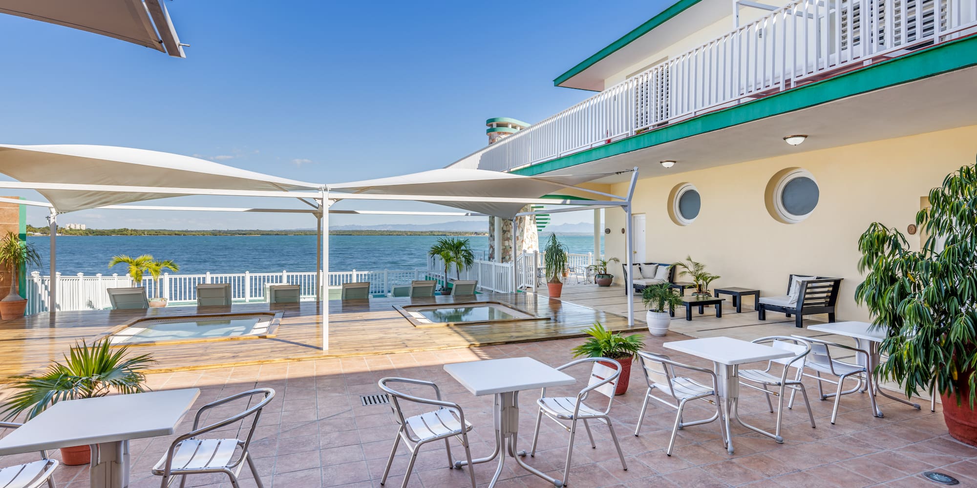 a patio with chairs and tables on a sunny day
