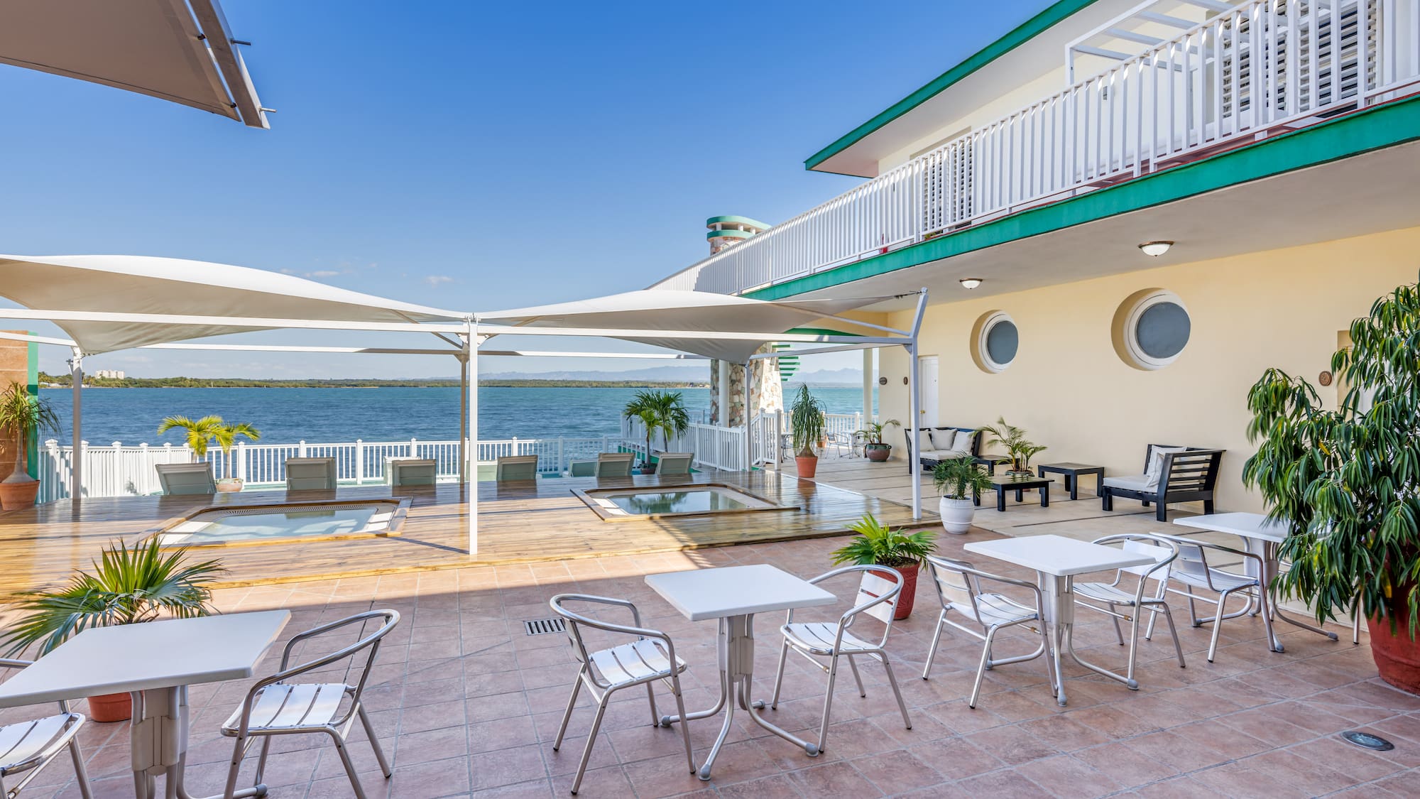 a patio with chairs and tables on a sunny day
