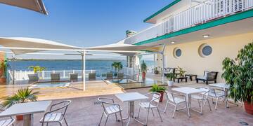 a patio with chairs and tables on a sunny day