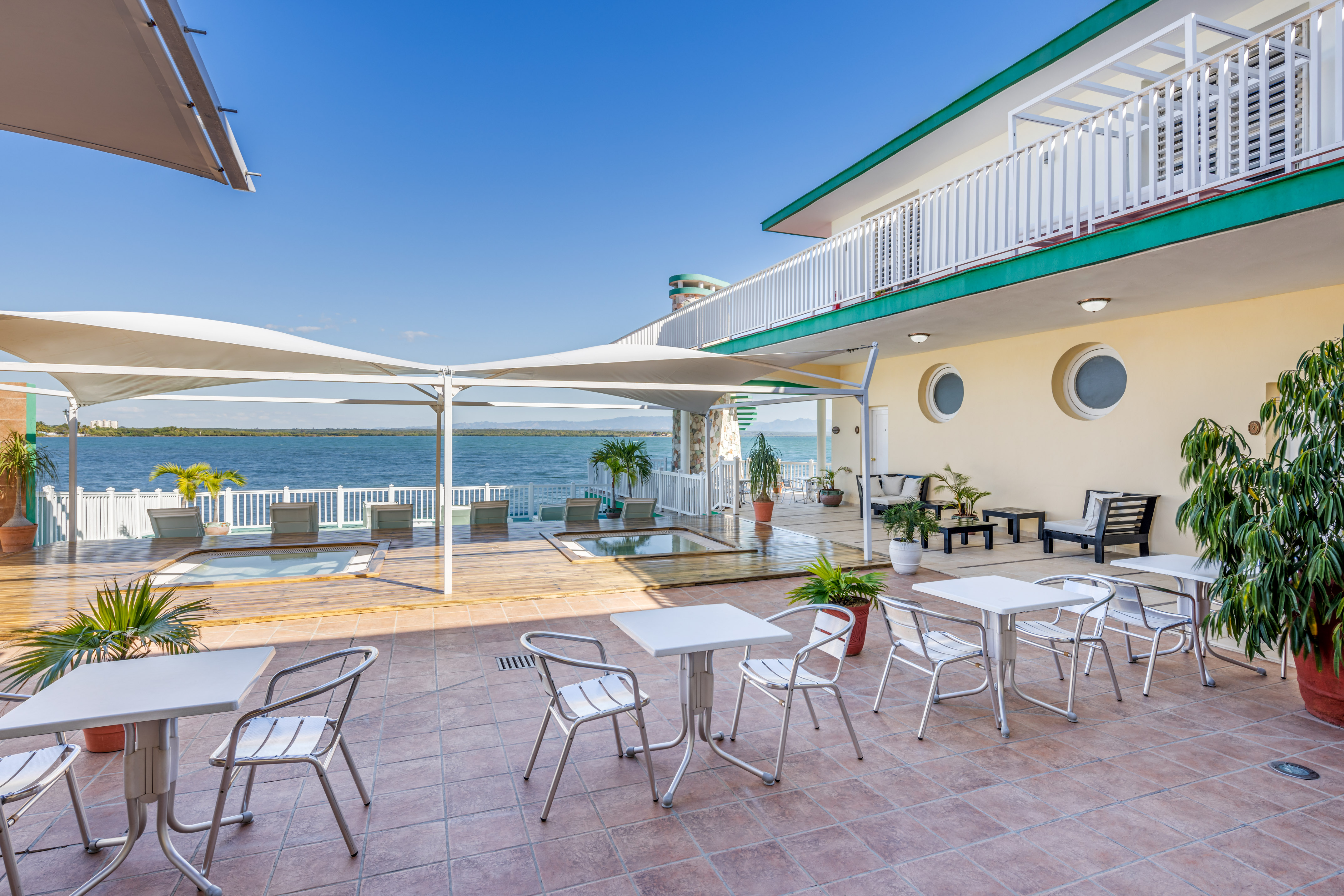 a patio with chairs and tables on a sunny day