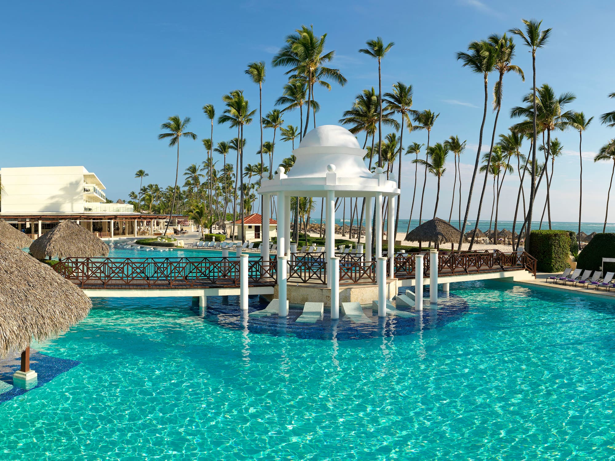 a gazebo over a pool with palm trees