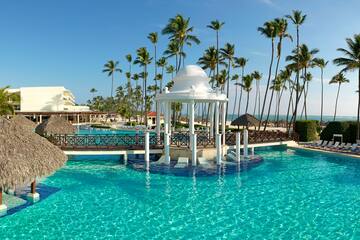 a gazebo over a pool with palm trees