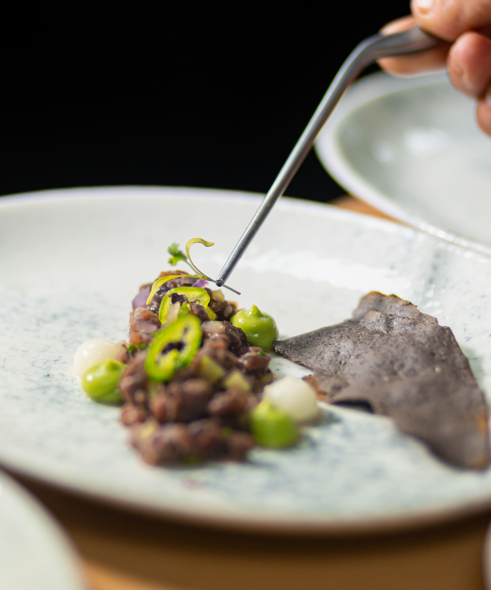 a person holding a fork over food on a plate