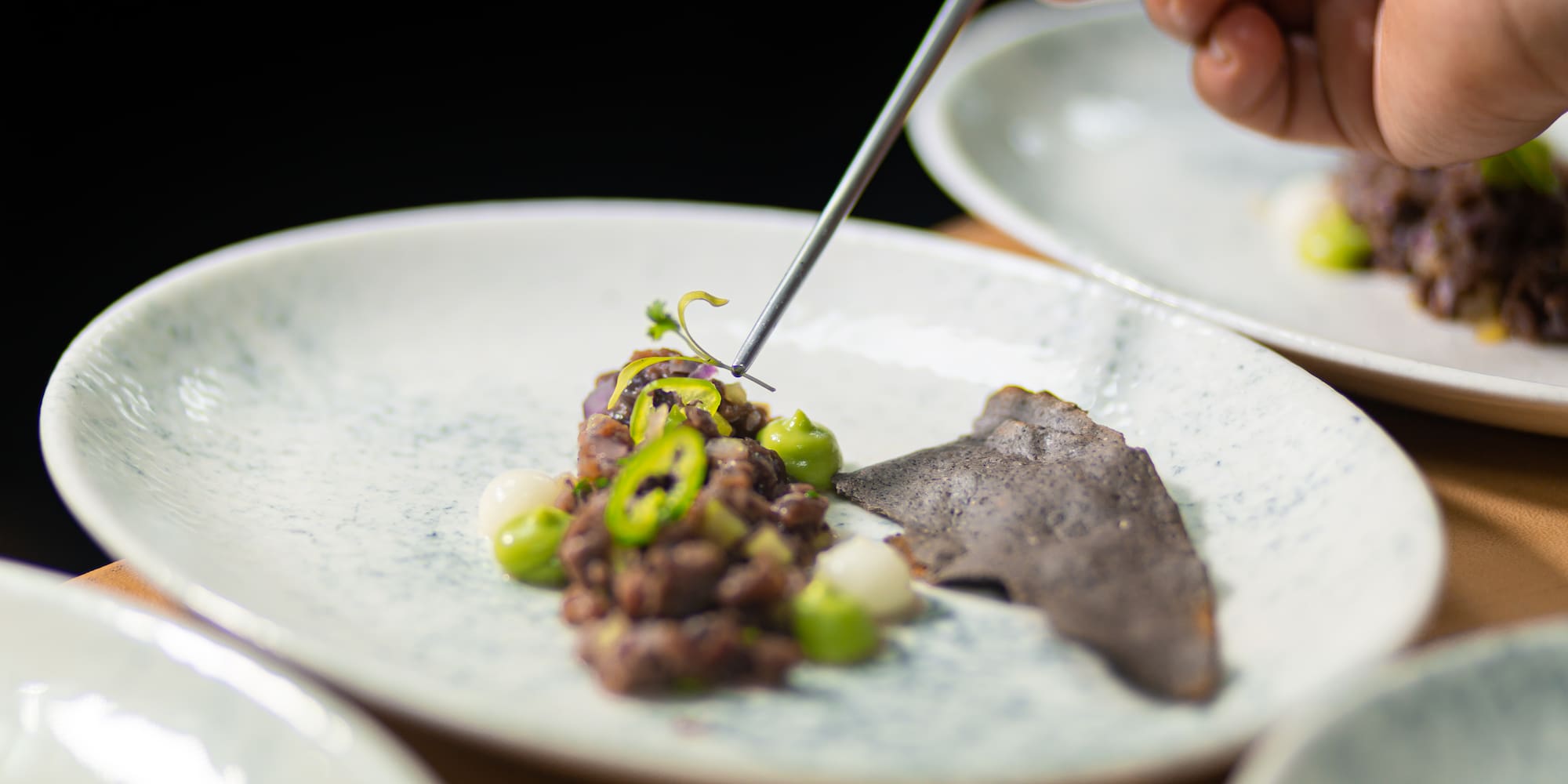 a person holding a fork over food on a plate