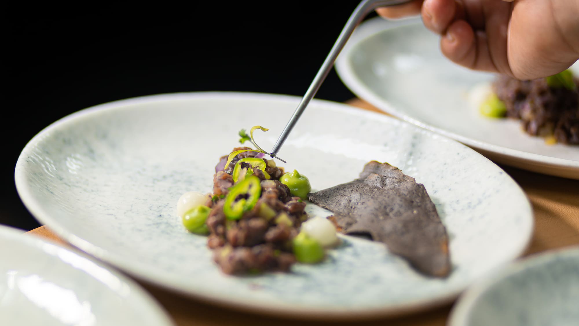 a person holding a fork over food on a plate