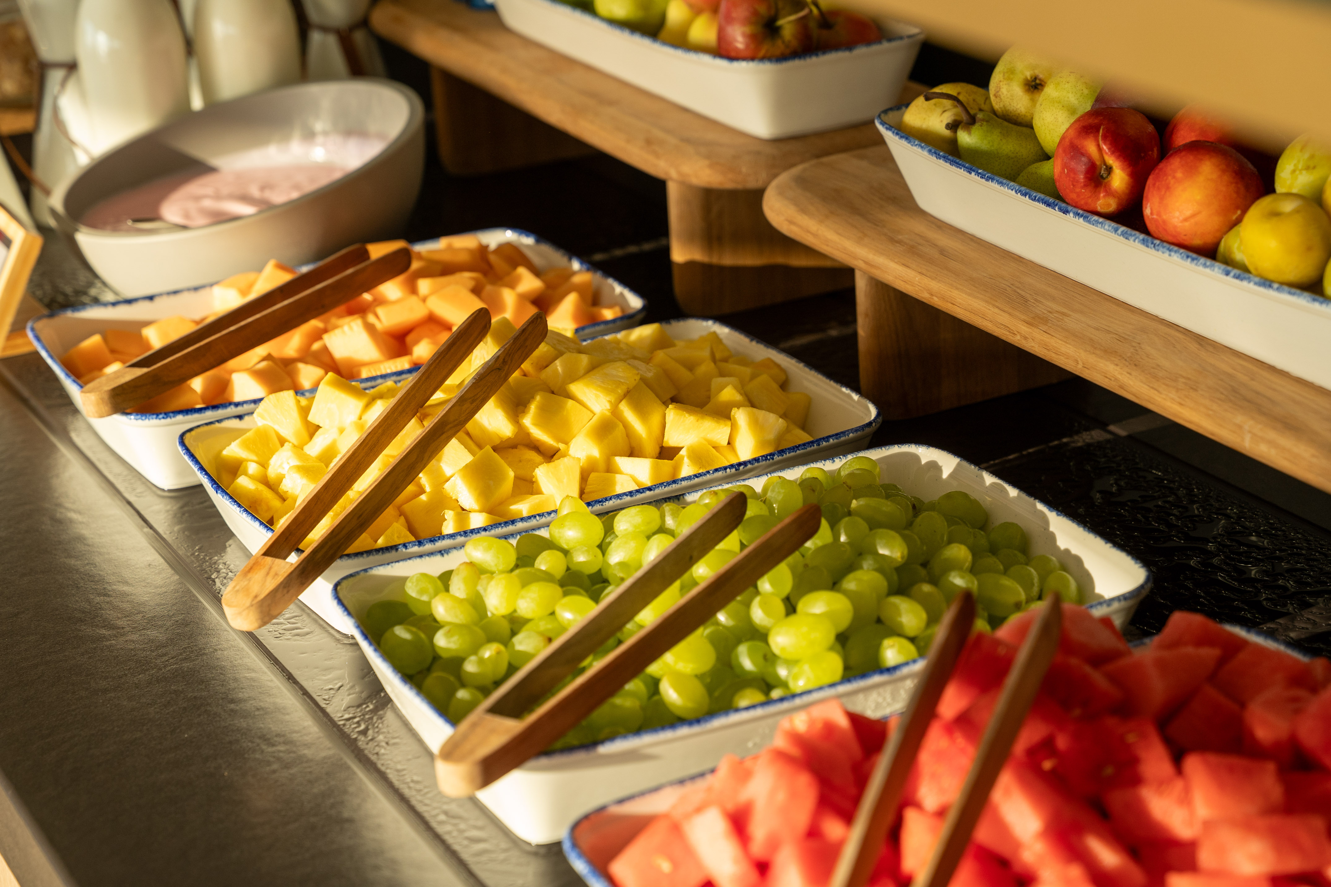 Fresh cut fruit buffet with pineapple, green grapes, cantaloupe, and watermelon.