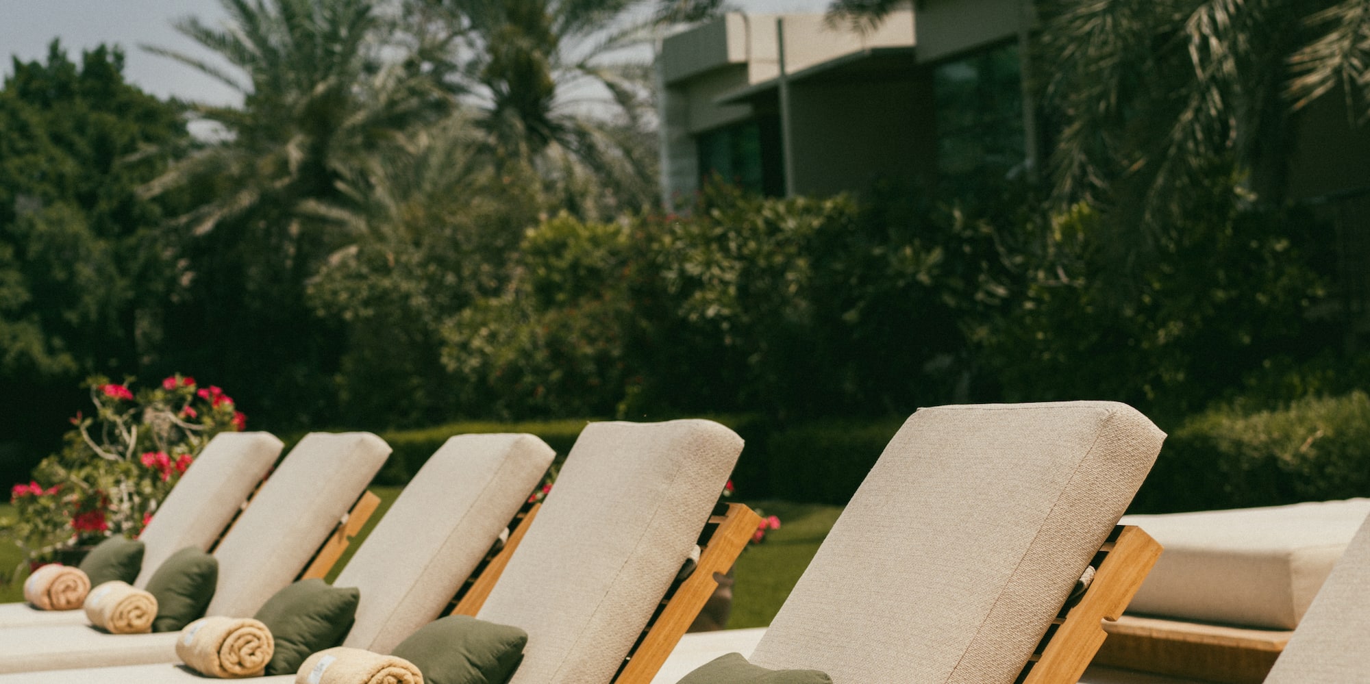 a group of lounge chairs with towels and a building in the background