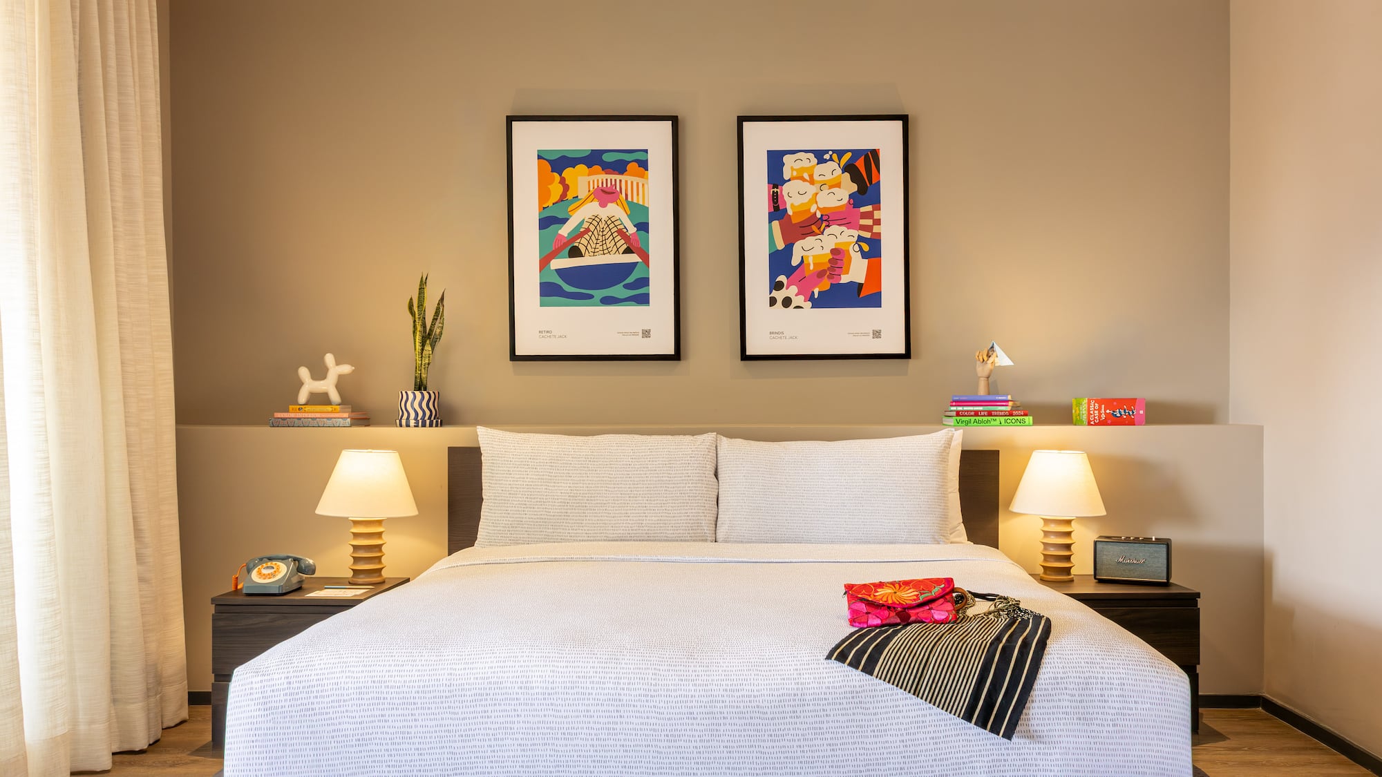 Cama de hotel con arte vibrante, lámparas y decoración contemporánea.