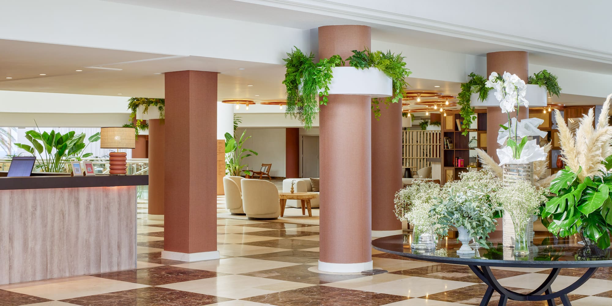 a lobby with a checkered floor and a table with flowers