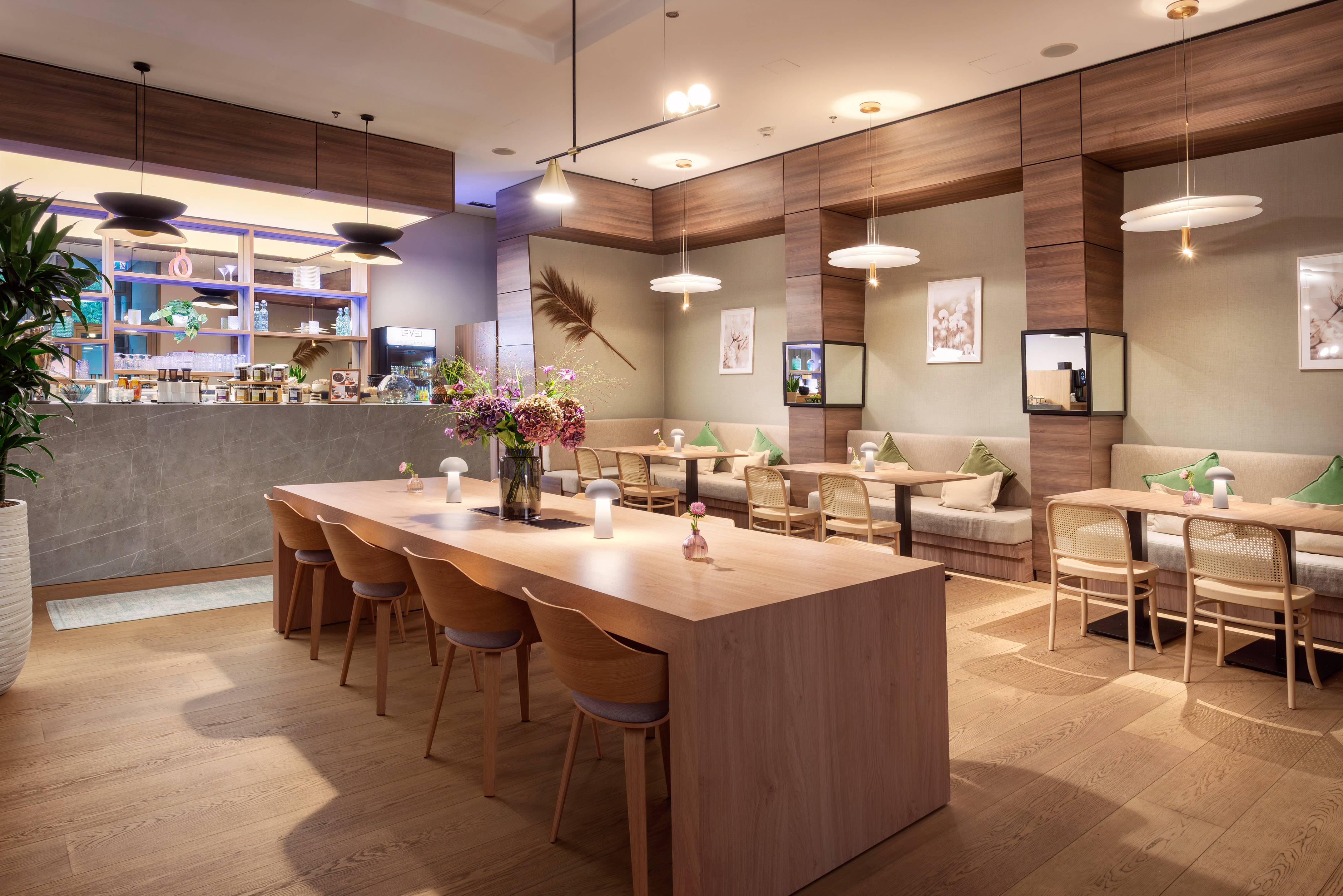 Modern cafe interior with communal table, booth seating, and bar.