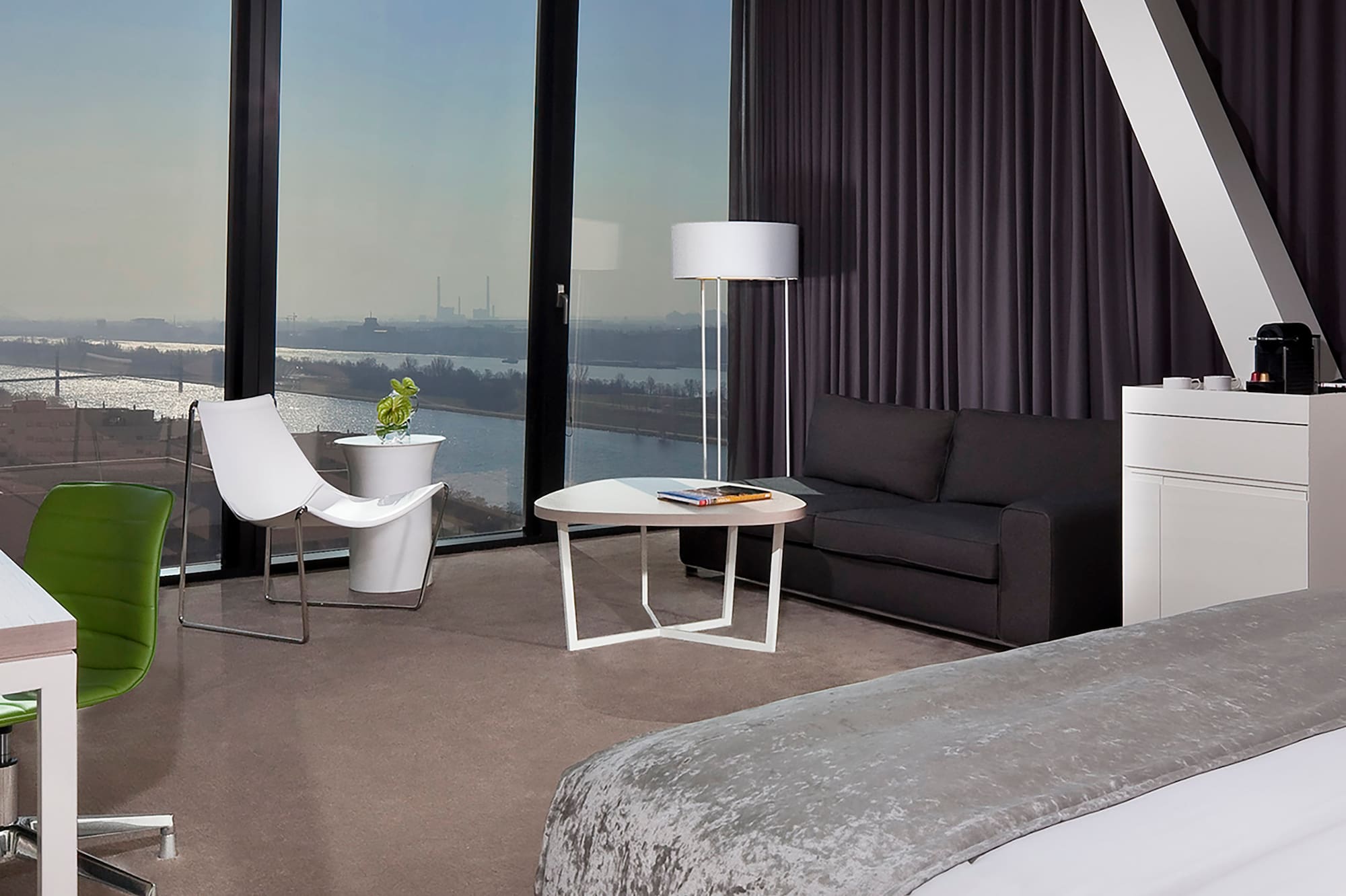 a room with a large window and a bed and a table