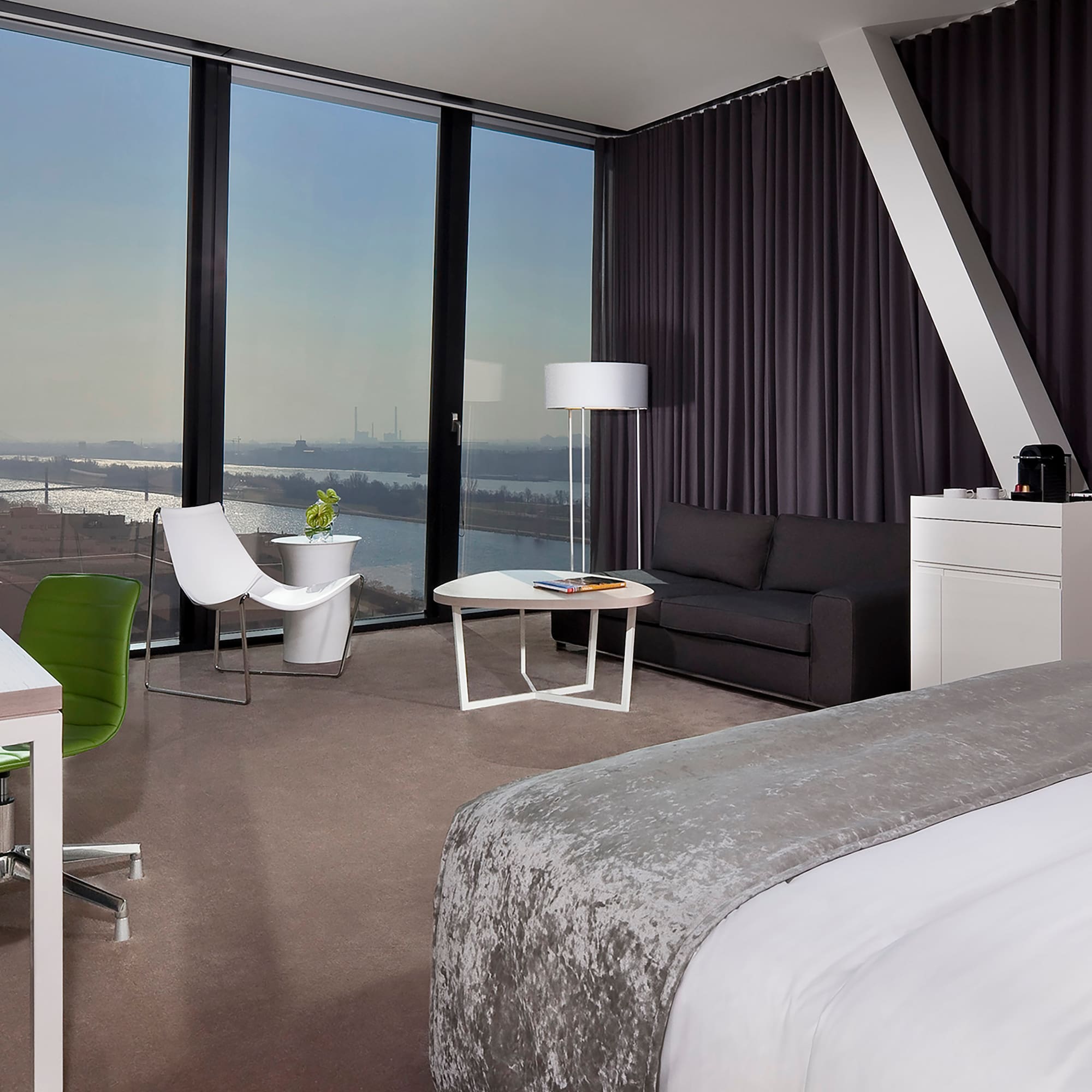 a room with a large window and a bed and a table