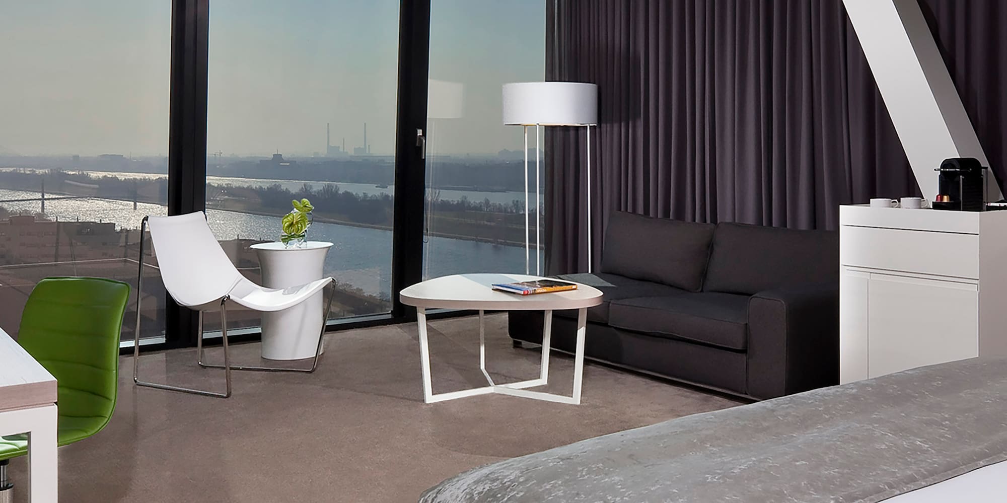 a room with a large window and a bed and a table