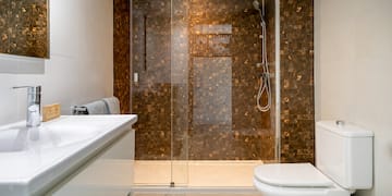 a bathroom with a glass shower door and sink