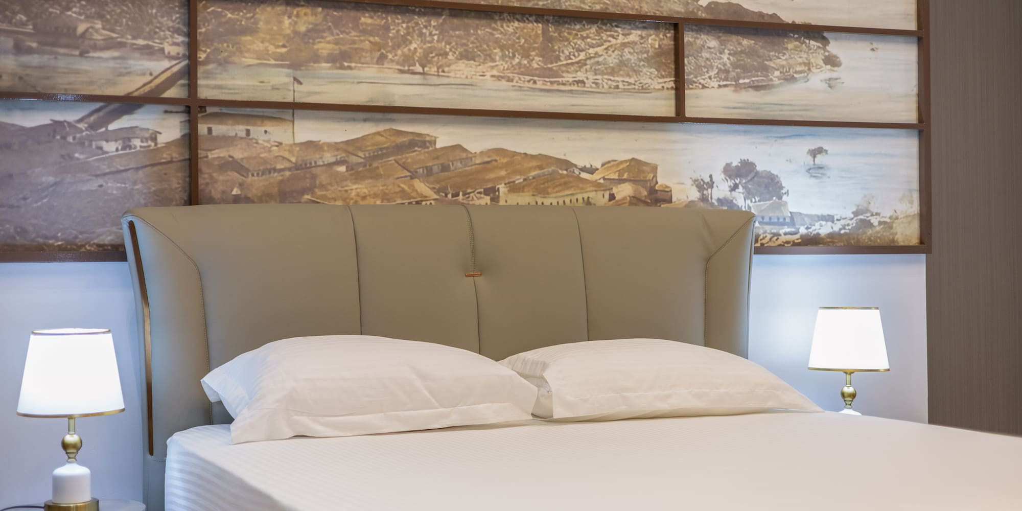 a bed with a lamp and a picture on the wall