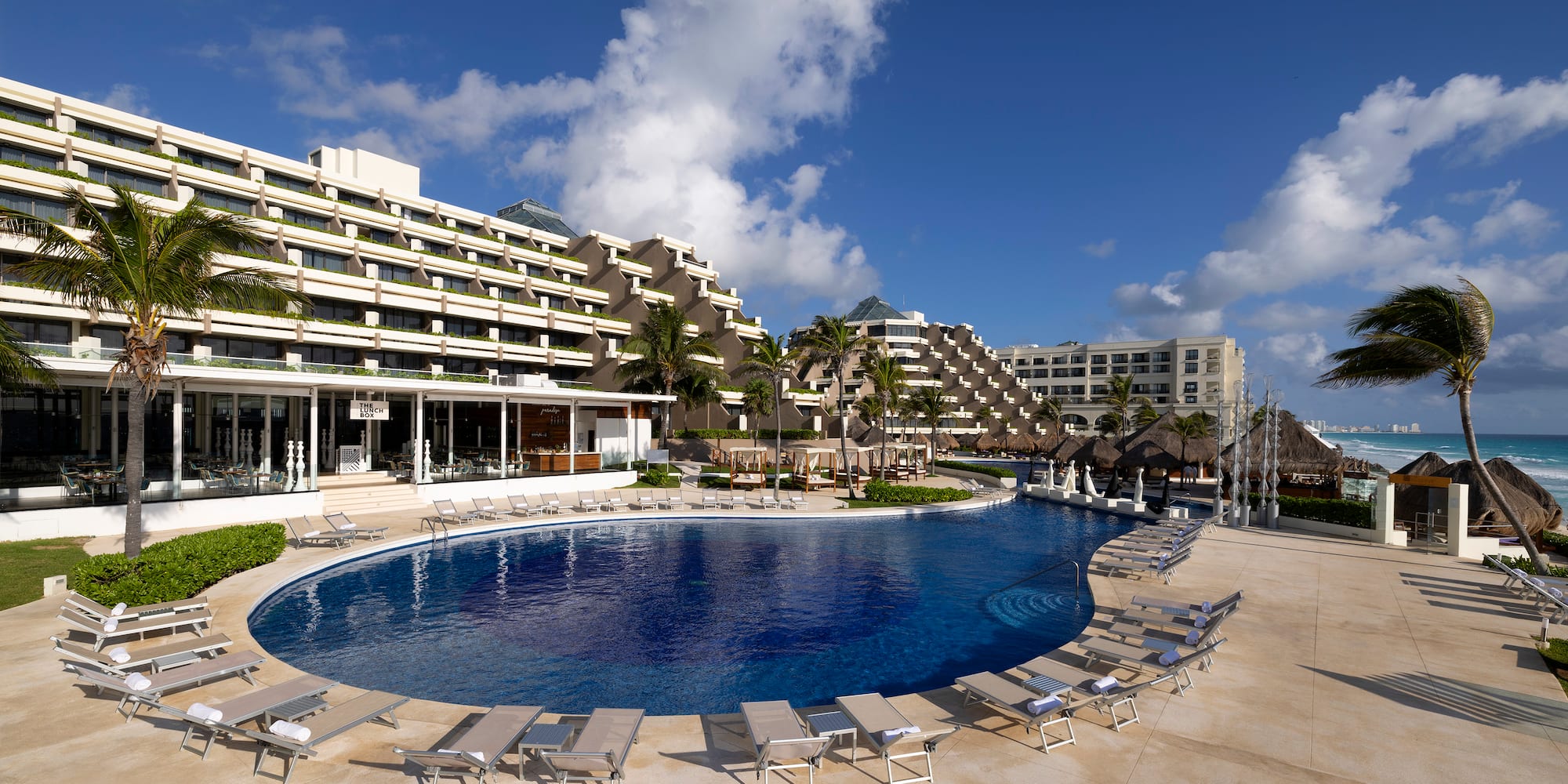 a pool with lounge chairs and a building in the background
