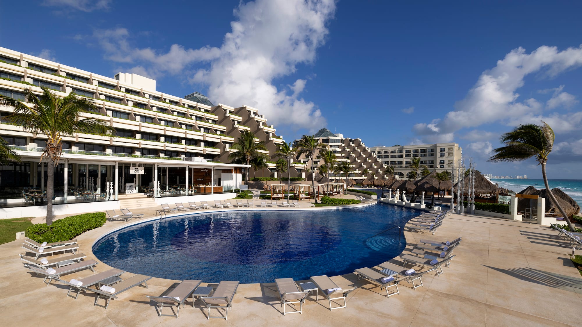 a pool with lounge chairs and a building in the background