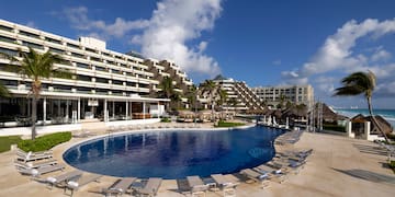 a pool with lounge chairs and a building in the background