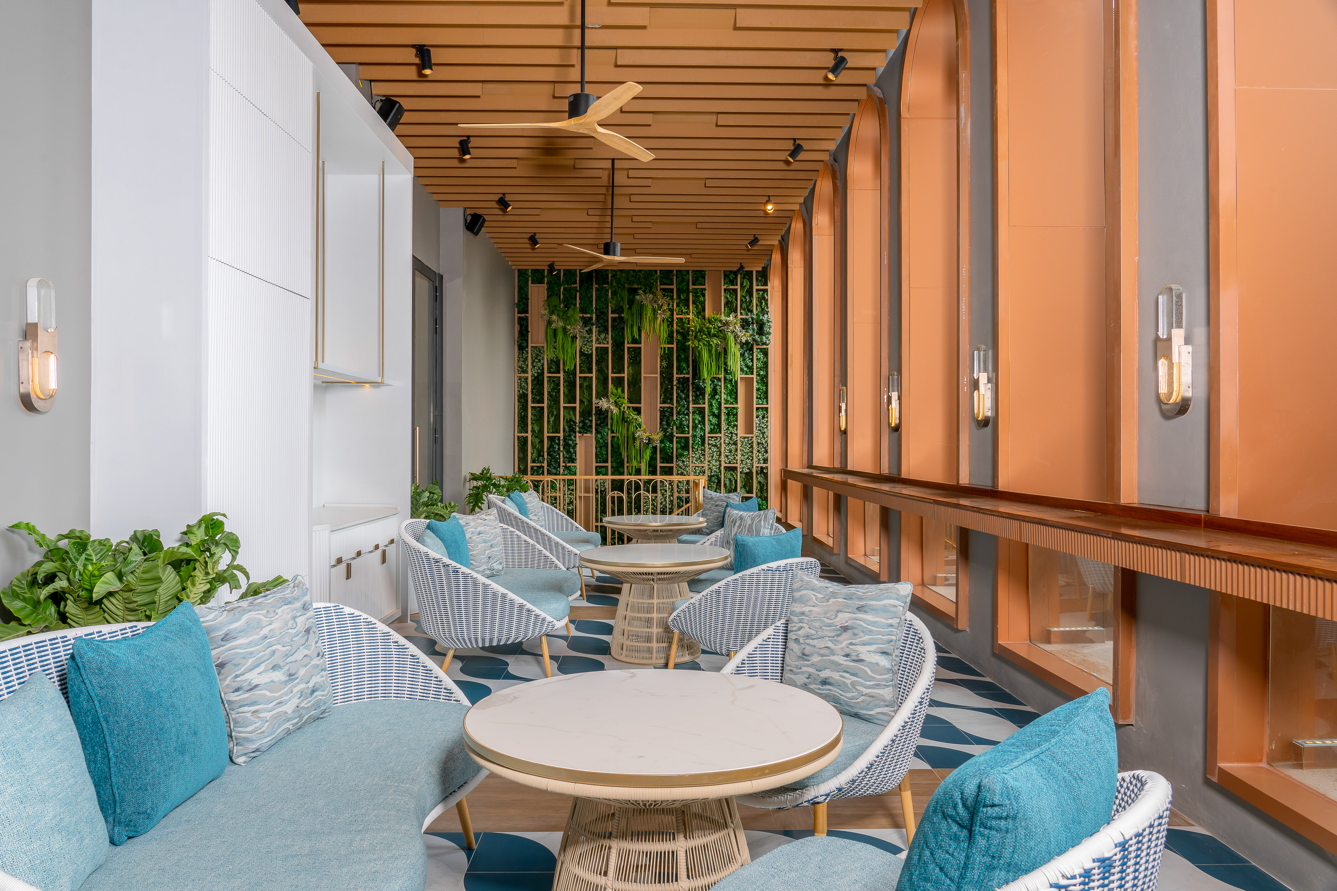 Stylish cafe lounge with blue and white seating, wood accents, and a living wall. - KaKi - Meliá Pattaya Hotel, Pattaya