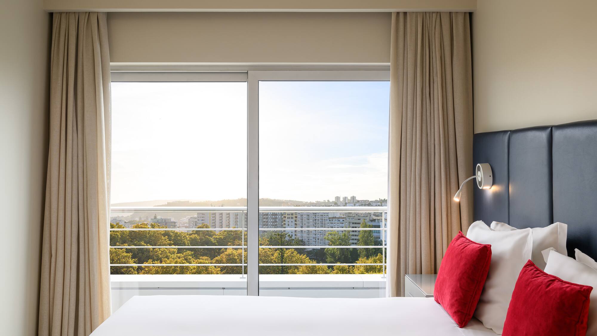a bed with a window and a view of the city