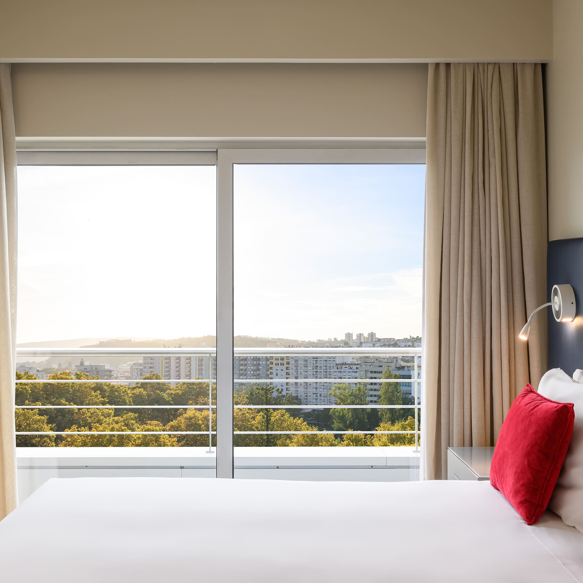 a bed with a window and a view of the city