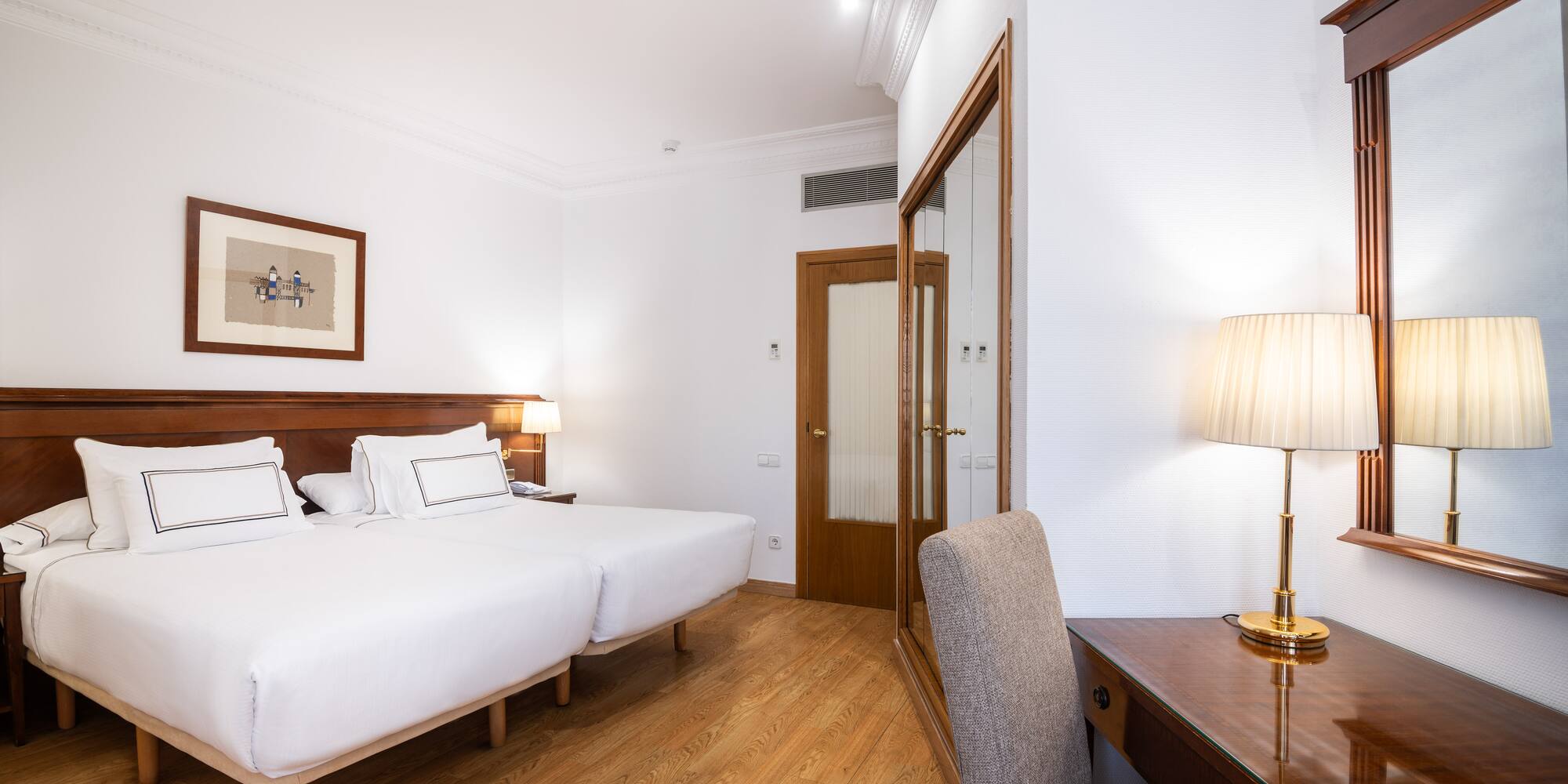 a room with two beds and a desk