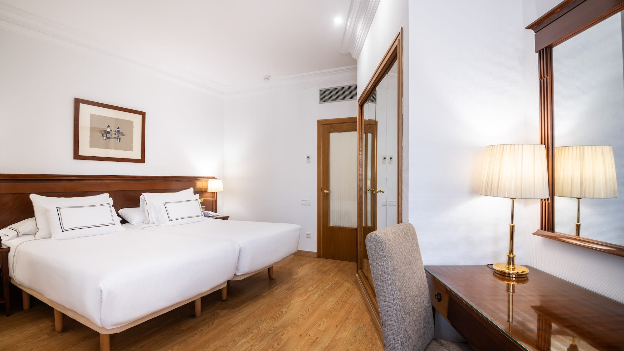 a room with two beds and a desk