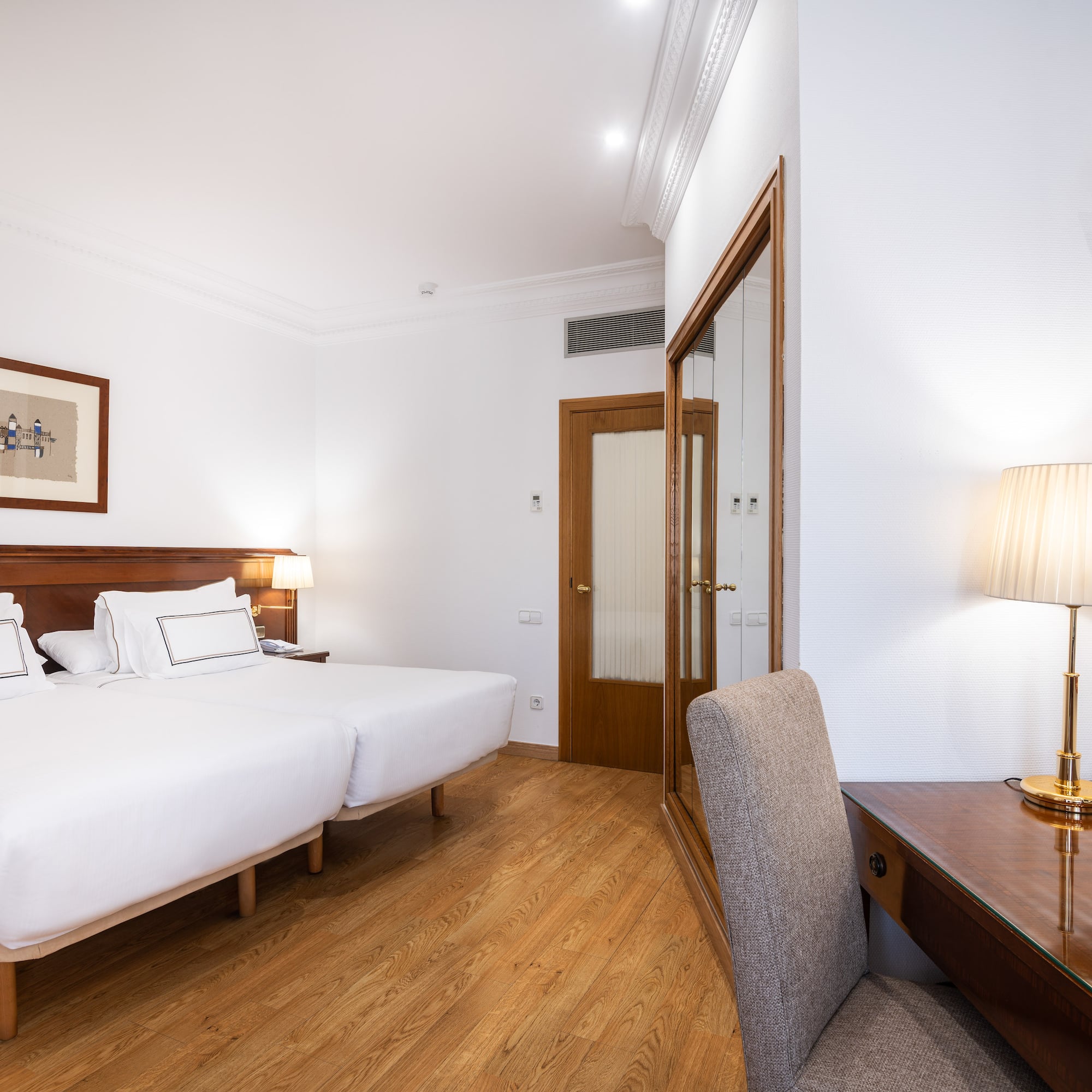 a room with two beds and a desk