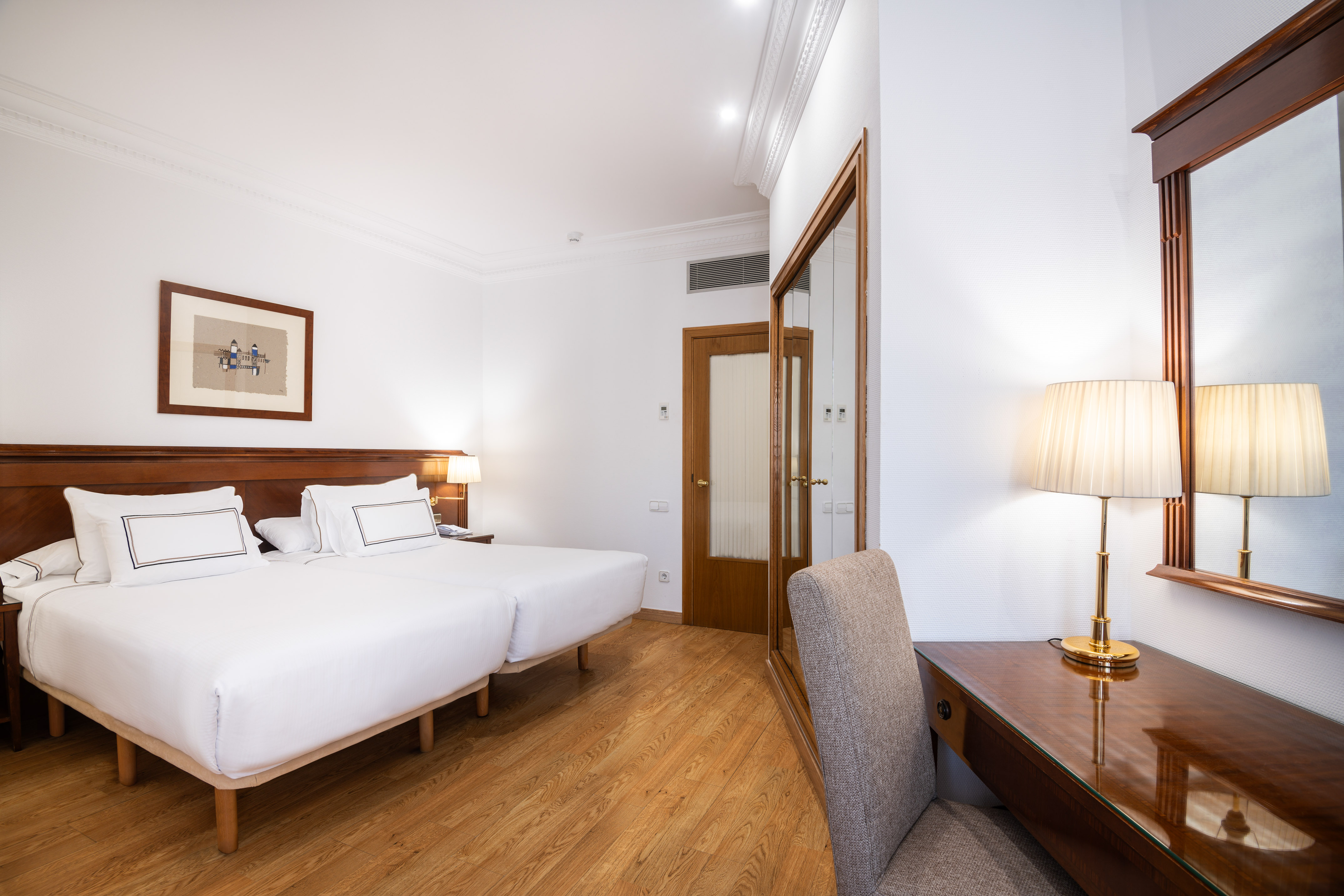 a room with two beds and a desk