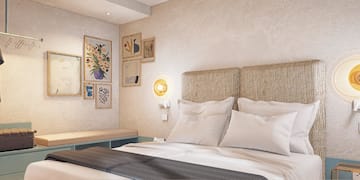 a bed with pillows and a bench in a room