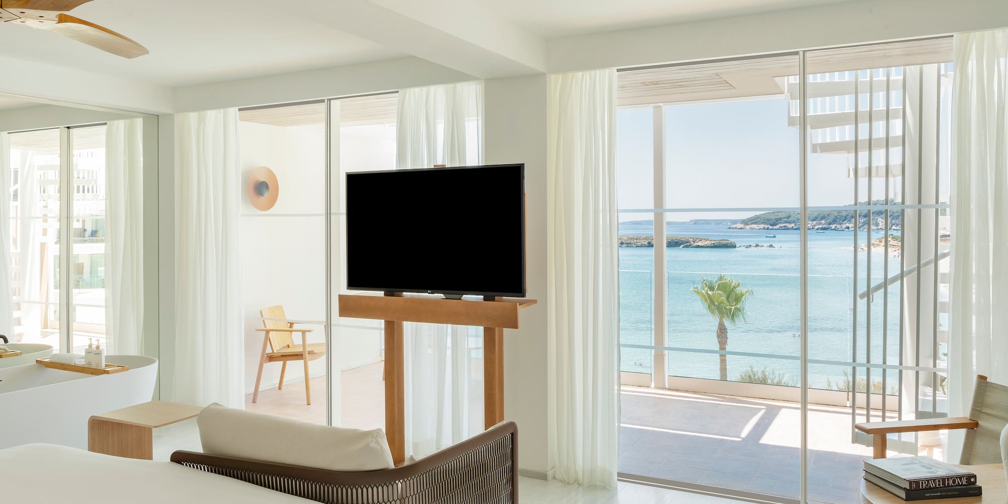 a room with a television and a view of the ocean