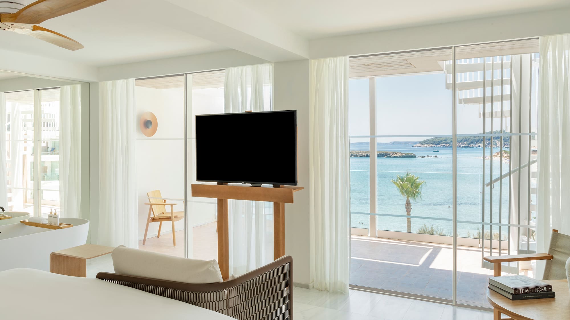 a room with a television and a view of the ocean