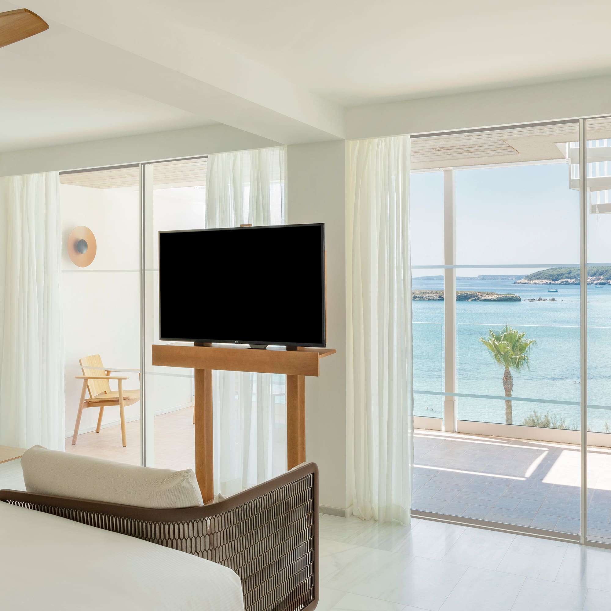 a room with a television and a view of the ocean