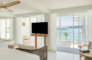 a room with a television and a view of the ocean