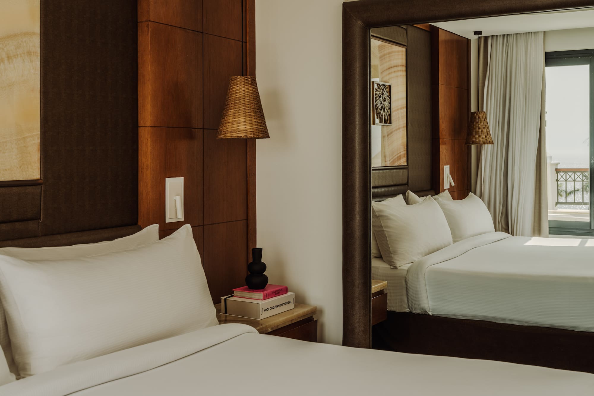 a mirror in a room with a bed and a lamp