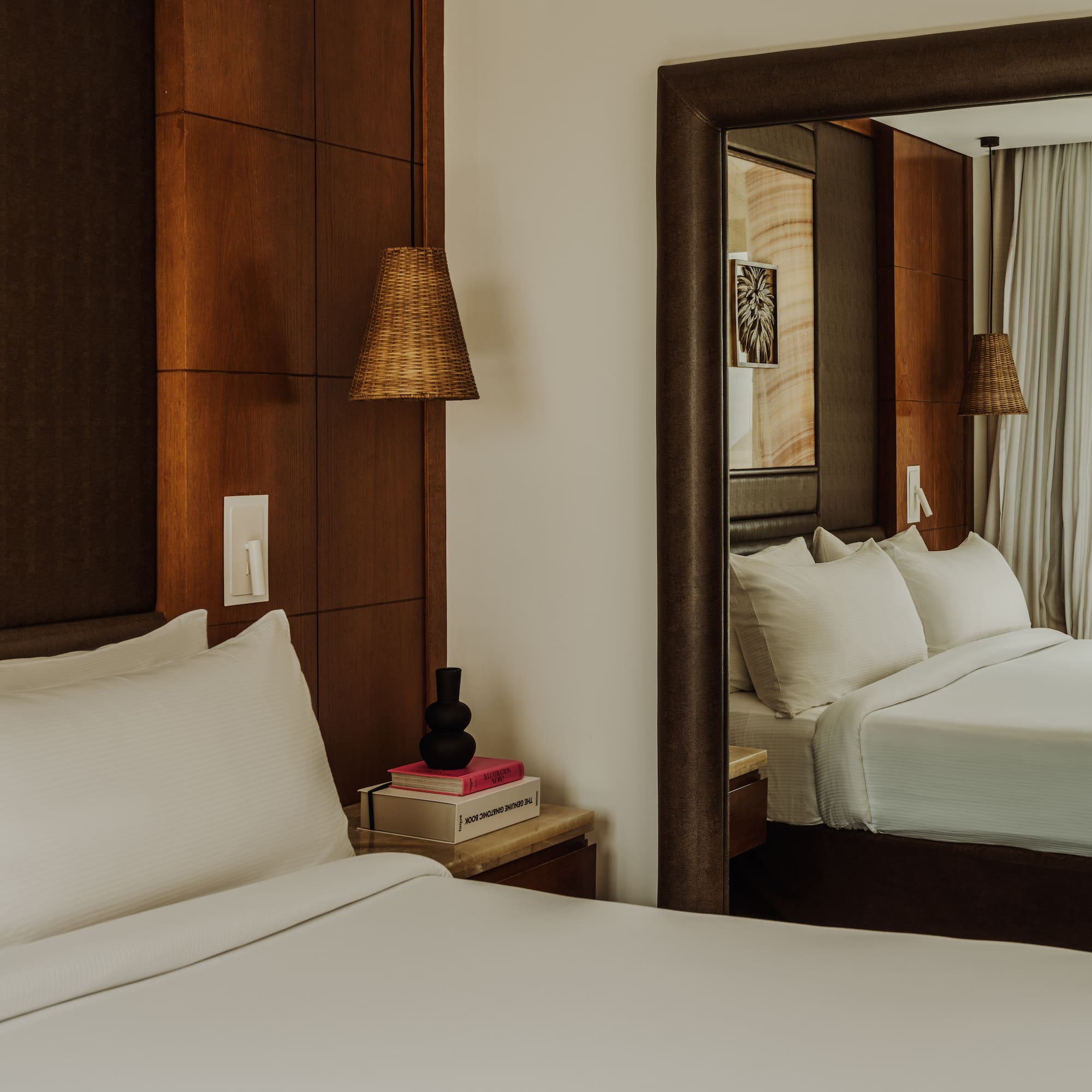 a mirror in a room with a bed and a lamp