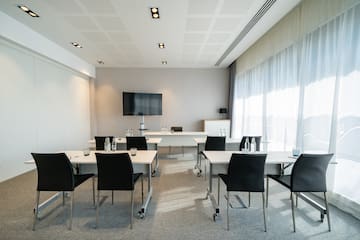 a room with white tables and black chairs