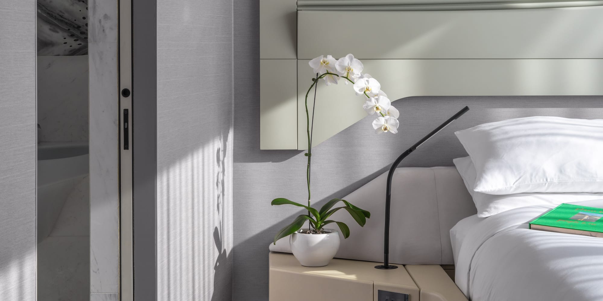 a plant on a table next to a bed