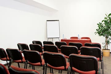 a room with red chairs and a white board