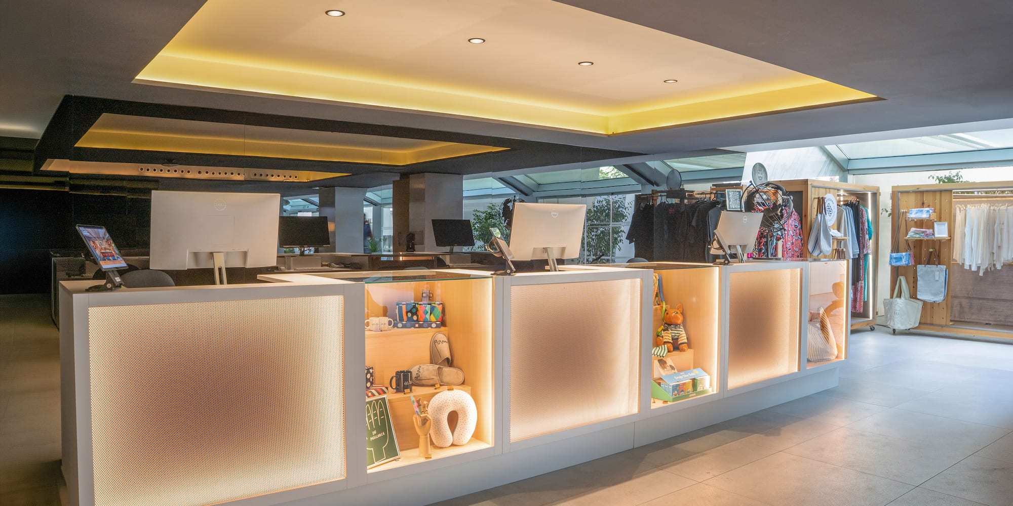Recepción de hotel con mostrador iluminado y tienda de souvenirs.
