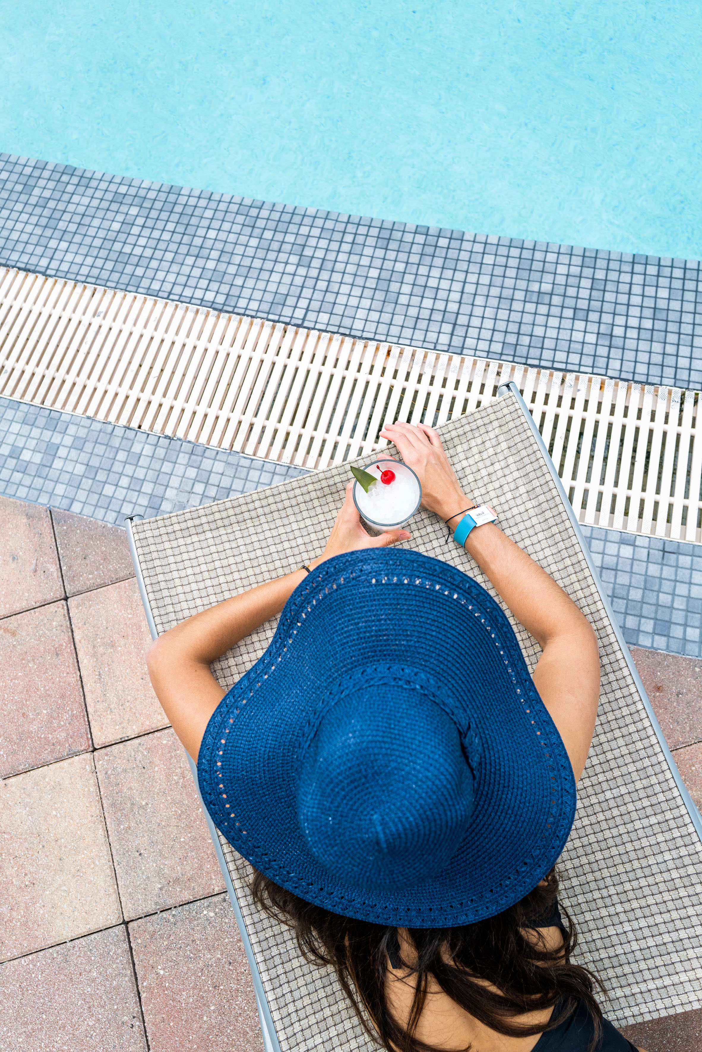 a person wearing a hat and holding a drink