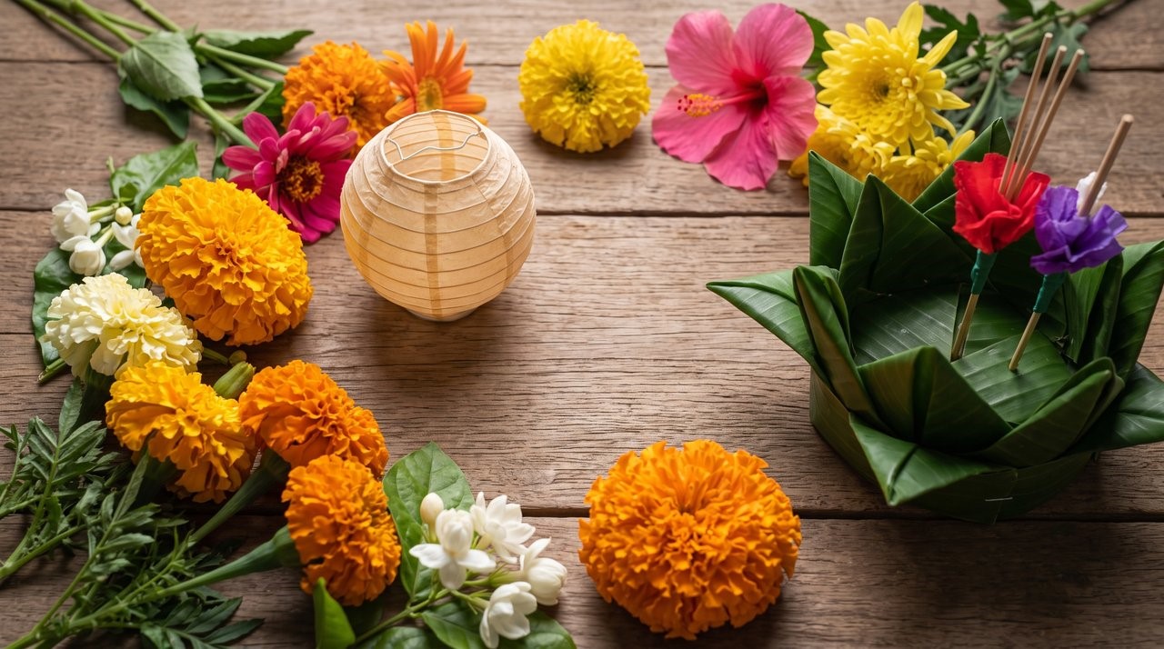 Loy Krathong float, colorful flowers, paper lantern on rustic wood.