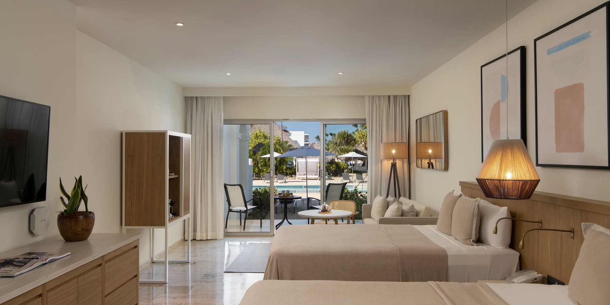 a room with two beds and a table and chairs