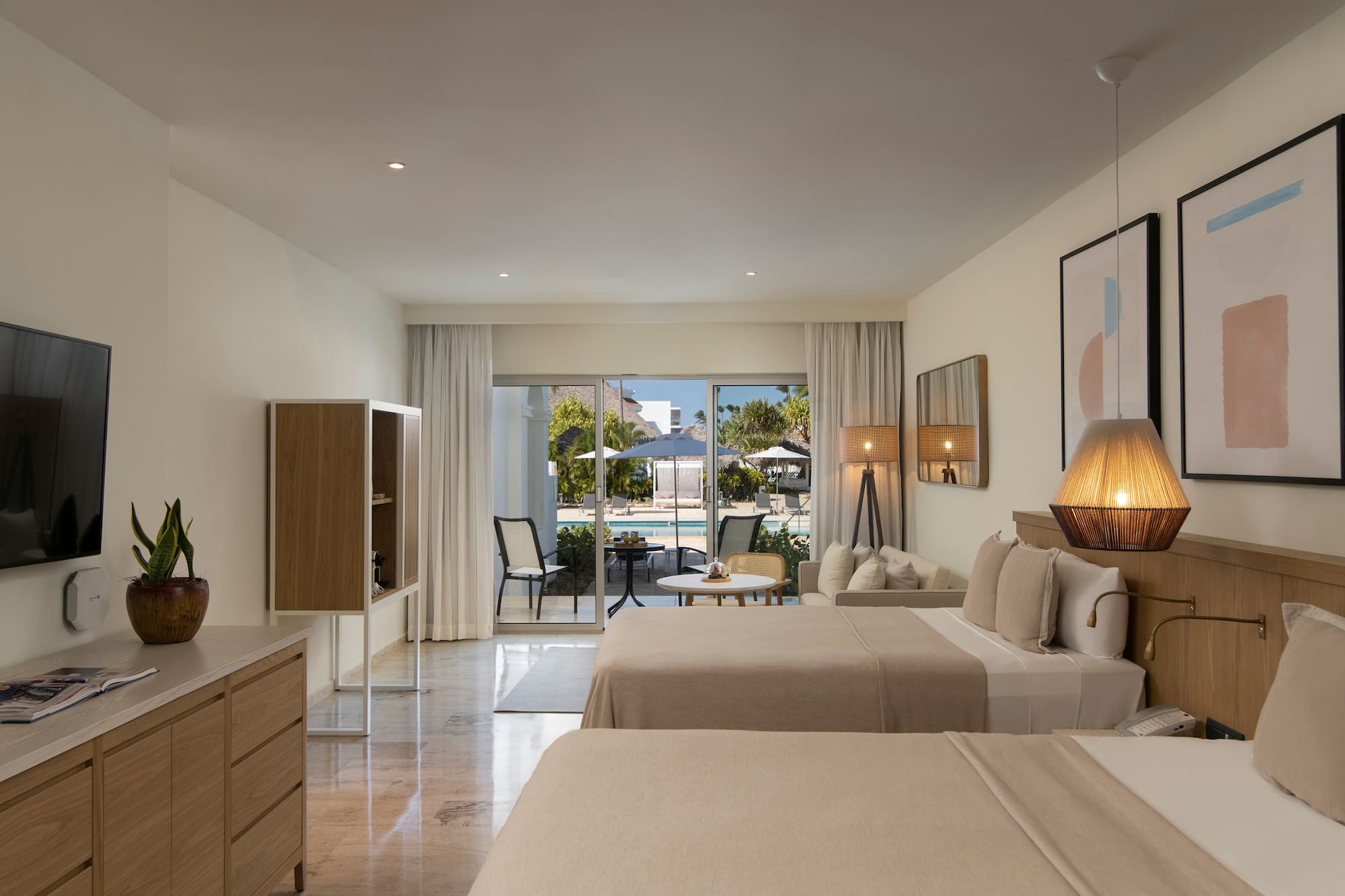 a room with two beds and a table and chairs