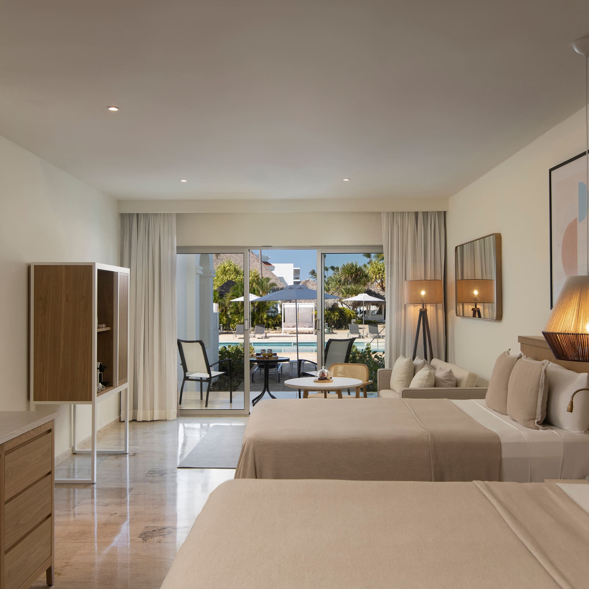 a room with two beds and a table and chairs