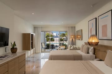 a room with two beds and a table and chairs